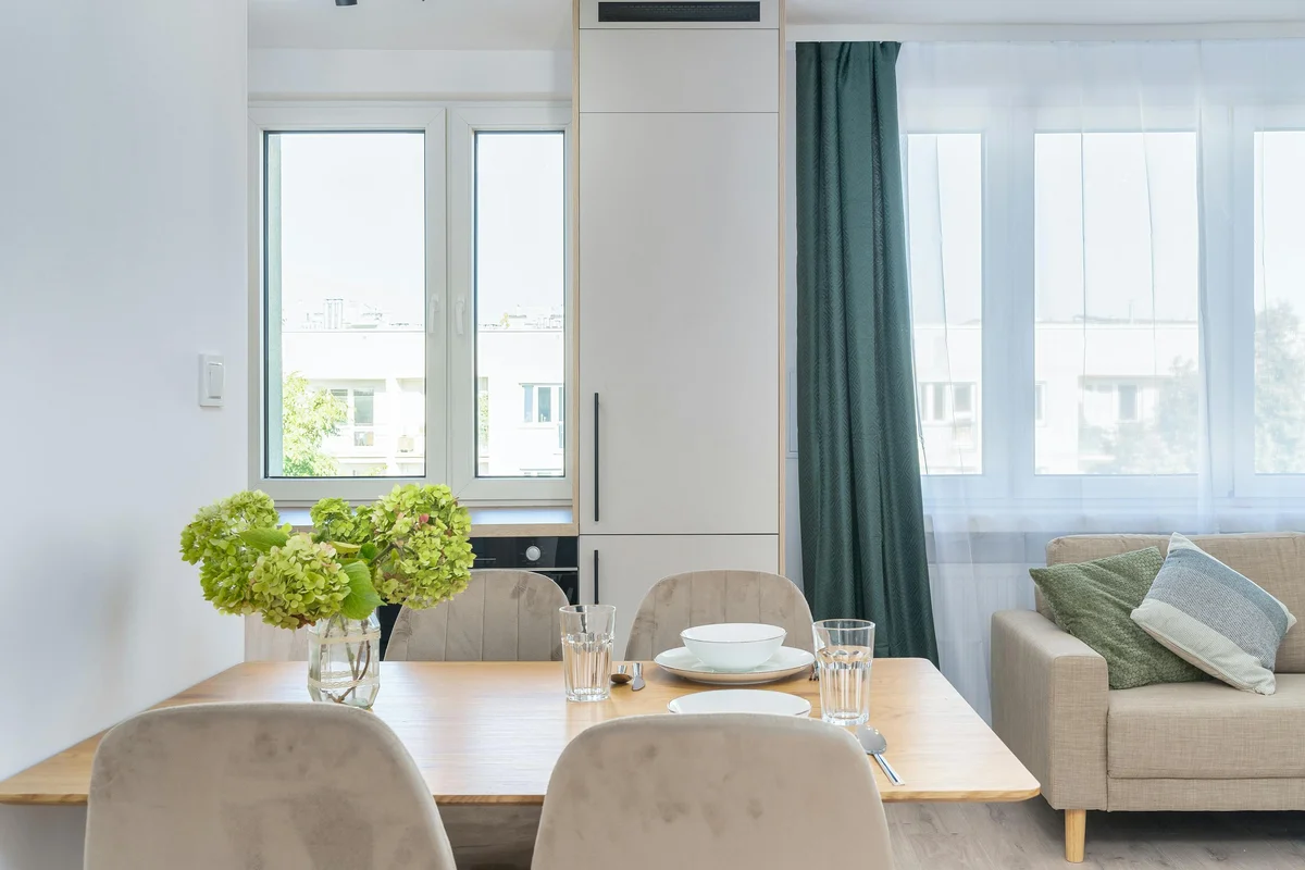 Helles, modernes Wohnzimmer mit Massivholz-Esstisch und Pflanzen - nachhaltiges Wohnen im Scandinavian-Style