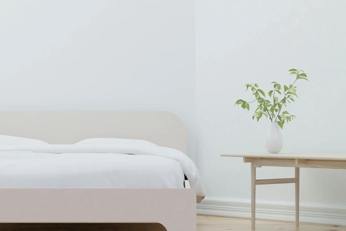 Minimalistisches Schlafzimmer mit Holz-Nachttisch und Pflanzenvase