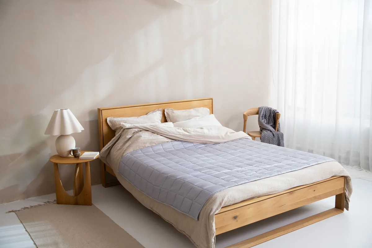 Schlafzimmer im Wabi-Sabi-Stil mit Massivholzbett und Leinenbettwäsche in Erdtönen
